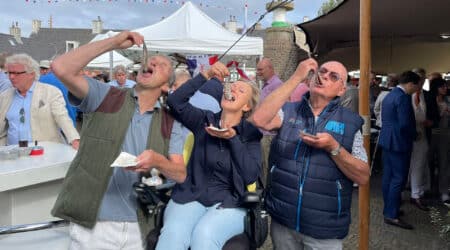 Wijkraadsleden happen een haring naar binnen