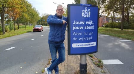 Secretaris Jonathan Weegink bij een campagnebord langs de weg