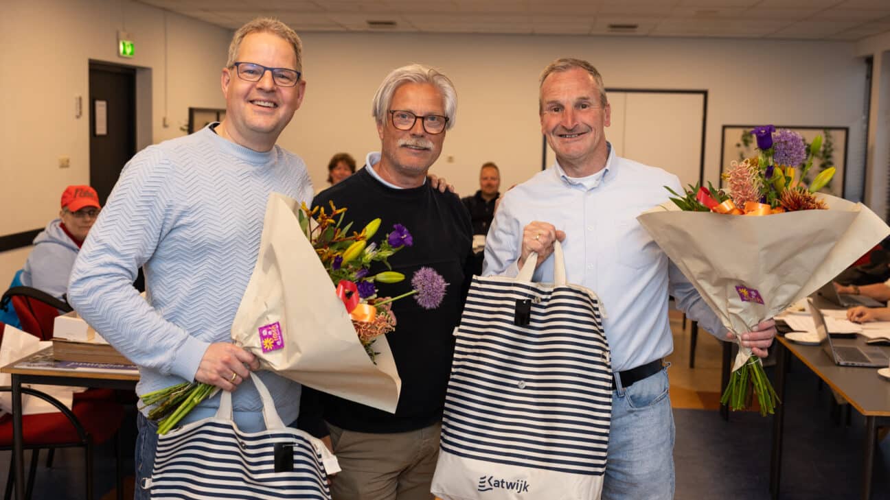 Jonathan (links) en Peter (rechts) met beiden een bos bloemen. In het midden Wijkregisseur Richard Onstenk