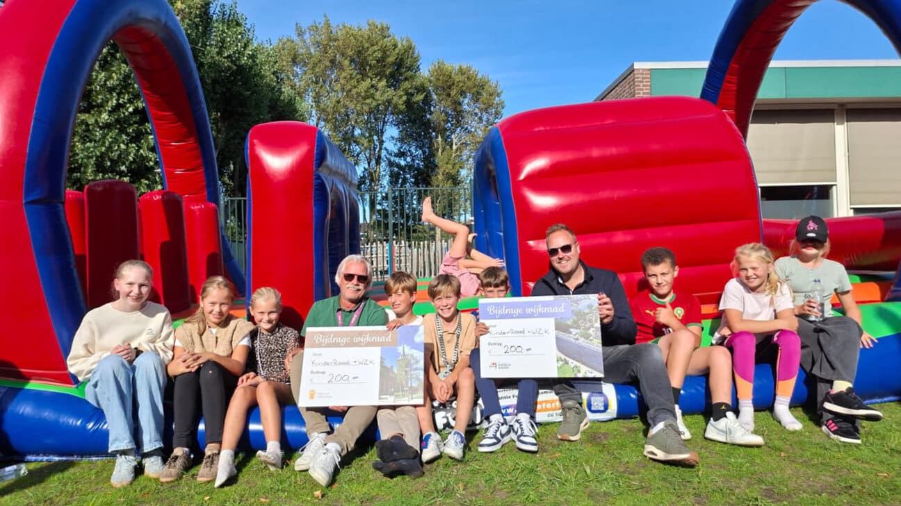kinderen van de Brugghenschool, met links wijkregisseur Richard Onstenk met een cheque namens Wijkraad Valkenburg en rechts Maarten Langbroek met een cheque namens Wijkraad Katwijk Noord.