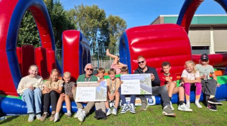 kinderen van de Brugghenschool, met links wijkregisseur Richard Onstenk met een cheque namens Wijkraad Valkenburg en rechts Maarten Langbroek met een cheque namens Wijkraad Katwijk Noord.